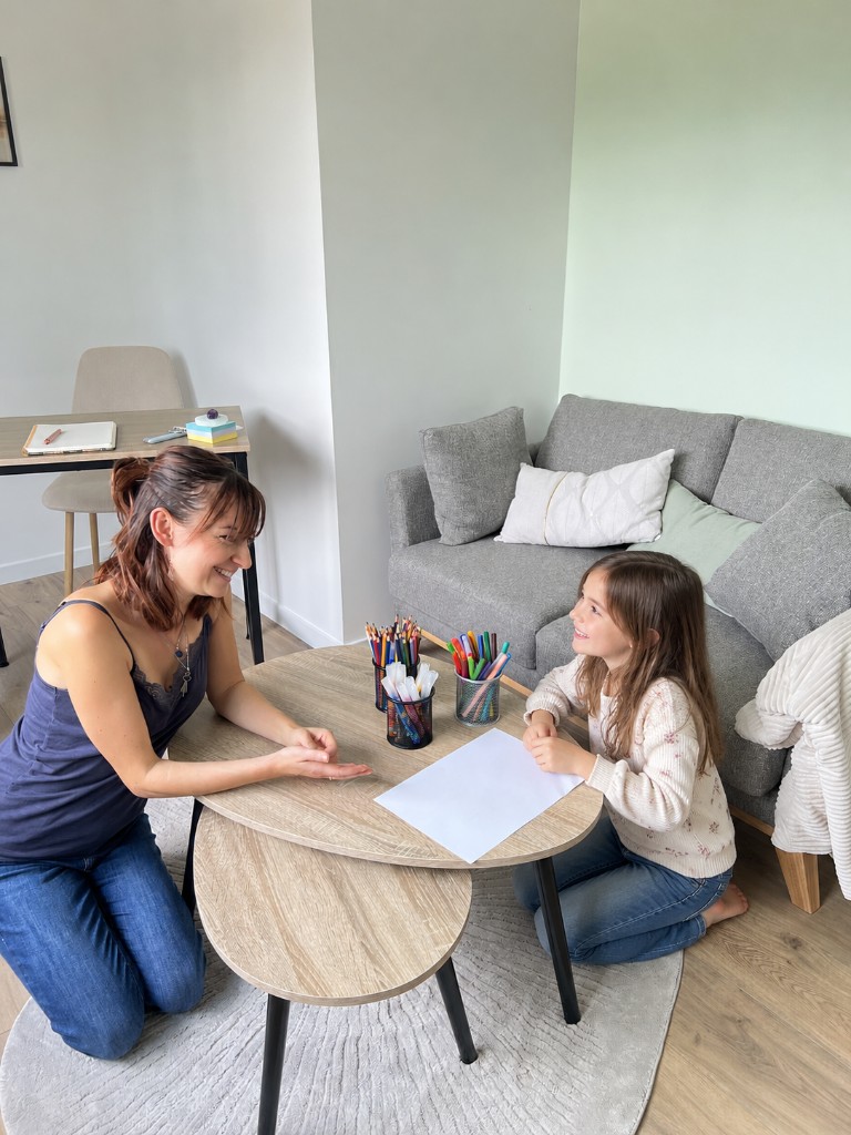 Morgane Del Medico à la table, face à un enfant, dans le cabinet